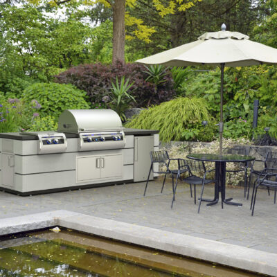 Botanical garden patio with table and chairs, E790i-9E1N Fire Magic Echelon Grill with 19-5B1N-0 Side Cooker.
